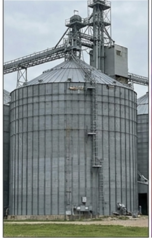 Visible-light photo of a corrugated steel grain bin and elevator leg