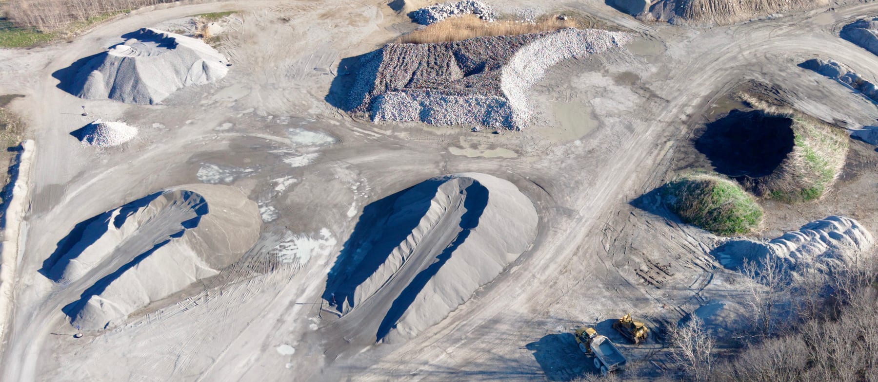 Aerial view of an active mining and aggregates site showing excavated terrain