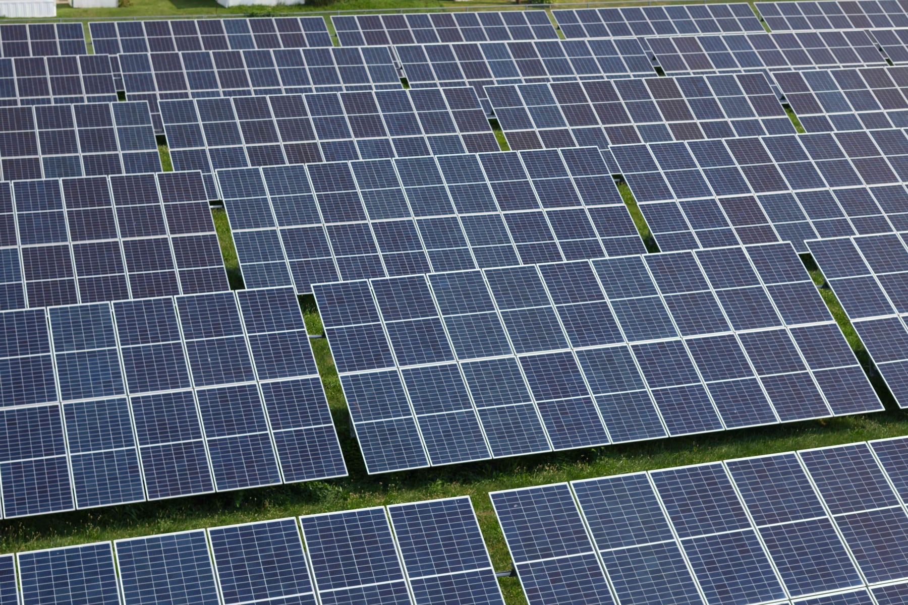 Aerial view of a utility-scale solar array with rows of photovoltaic panels